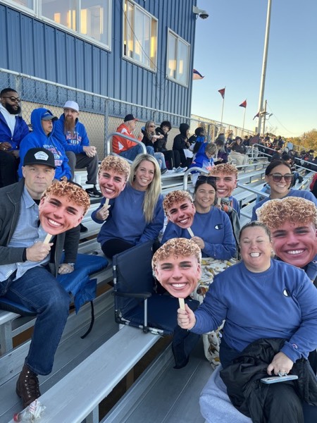Family cheering with custom face signs at a game